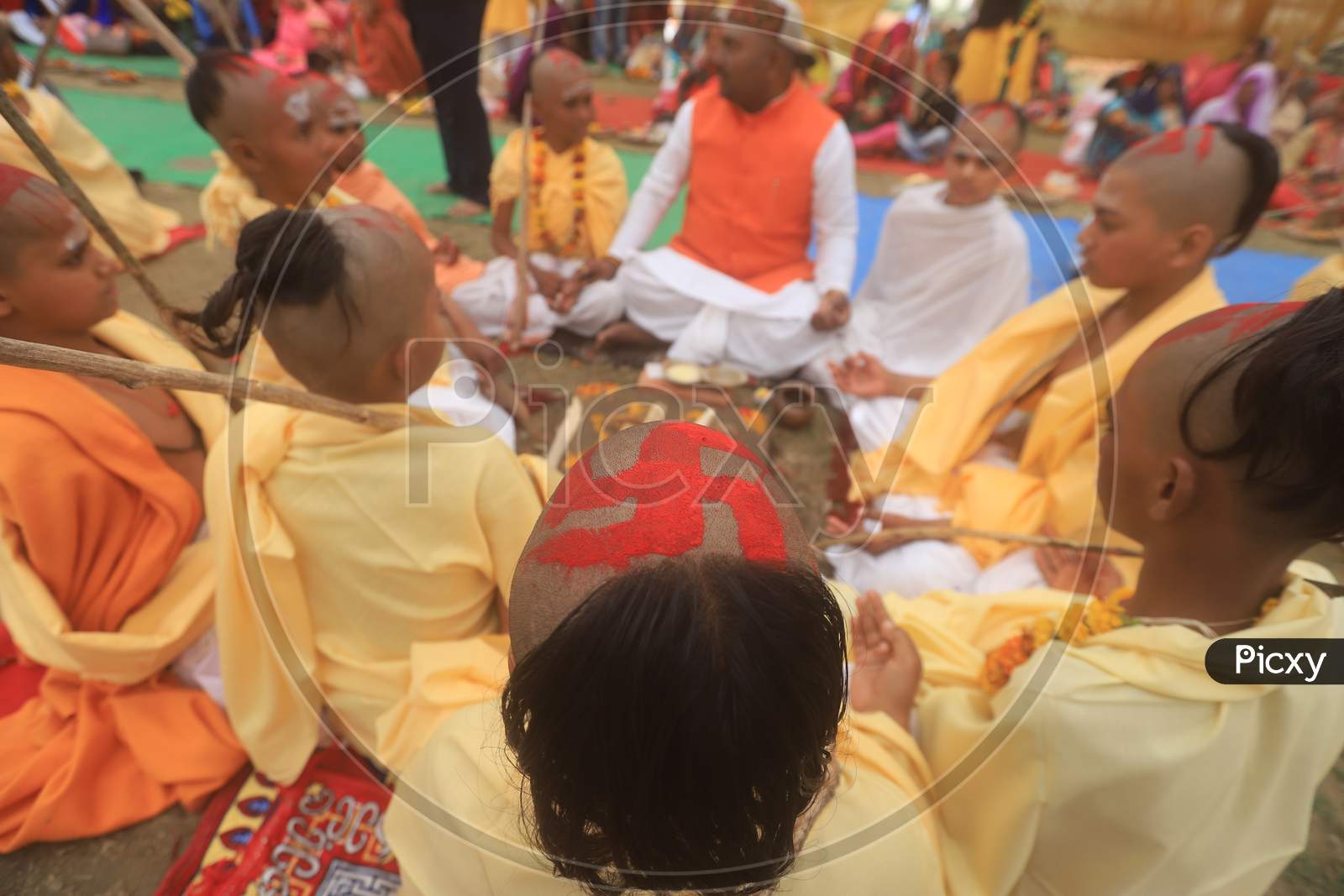 Indian Hindu Bramhin Boy Or Priest  With Swasthik Symbol On Tonsure Head  At Homam During Magh Mela . prayagraj 2020