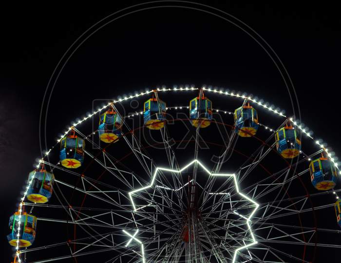 Long Exposure Of Giant Wheel in a Fair With Neon Lights