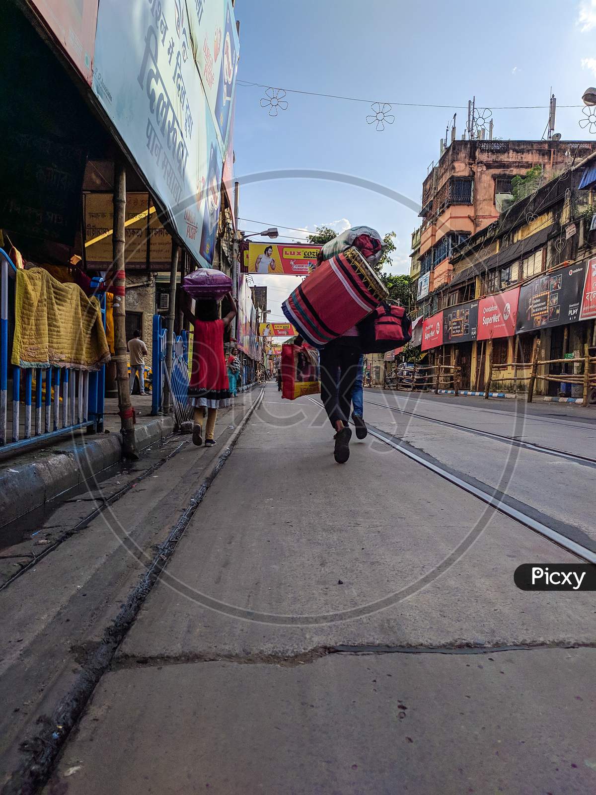 People Walking On Street Carrying Luggage on Head