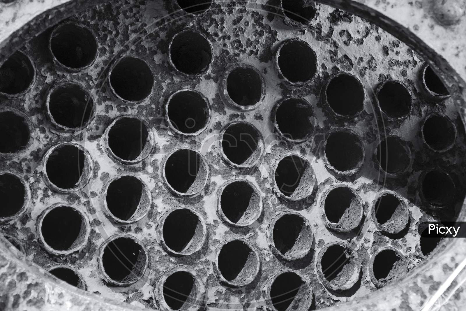 Holes in an Drain Pipe Closeup With Patterns