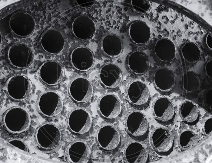 Holes in an Drain Pipe Closeup With Patterns