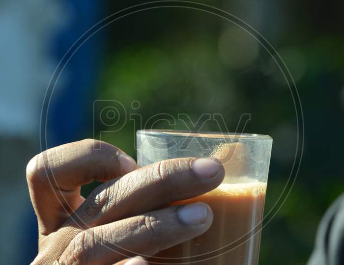 A Man Holding a Tea Glass