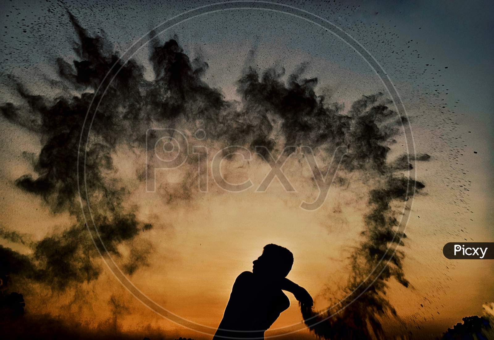 Silhouette Of Man With Sand Splash Over Sunset Sky