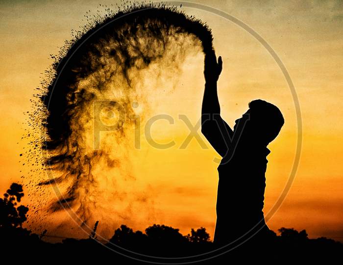 Silhouette Of Man With Sand Splash Over Sunset Sky