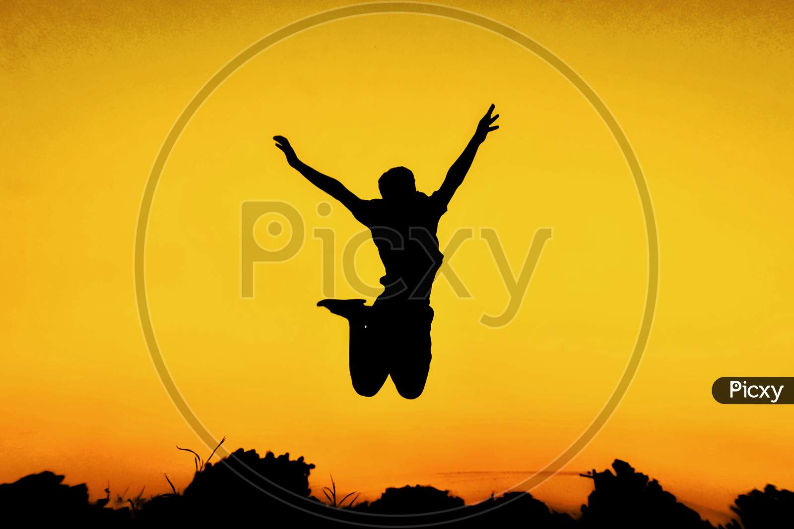 Silhouette Of Man Jumping In Joy  Over Golden Sky Background