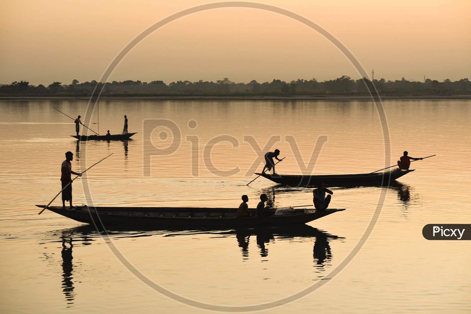 Silhouette Of  Indian Fishermen Fishing In Beki River During Sunset, At Sarbhog In Barpeta District Of Assam