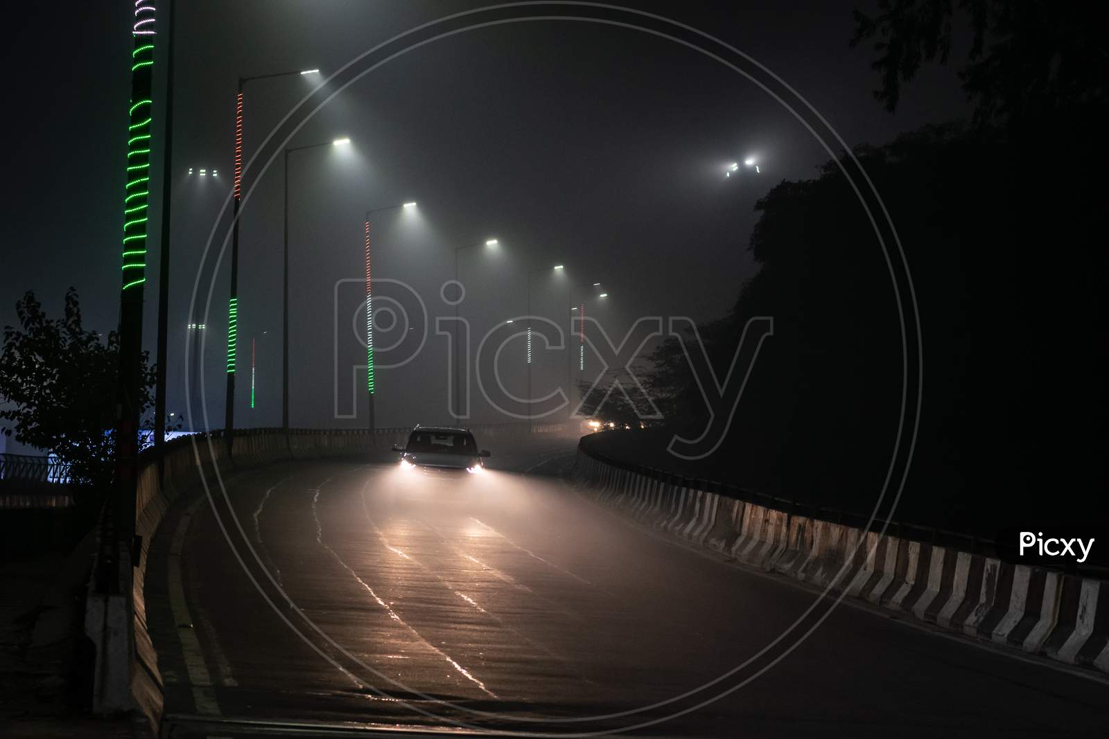 A car passing over flyover during one foggy night during winters in Delhi NCR