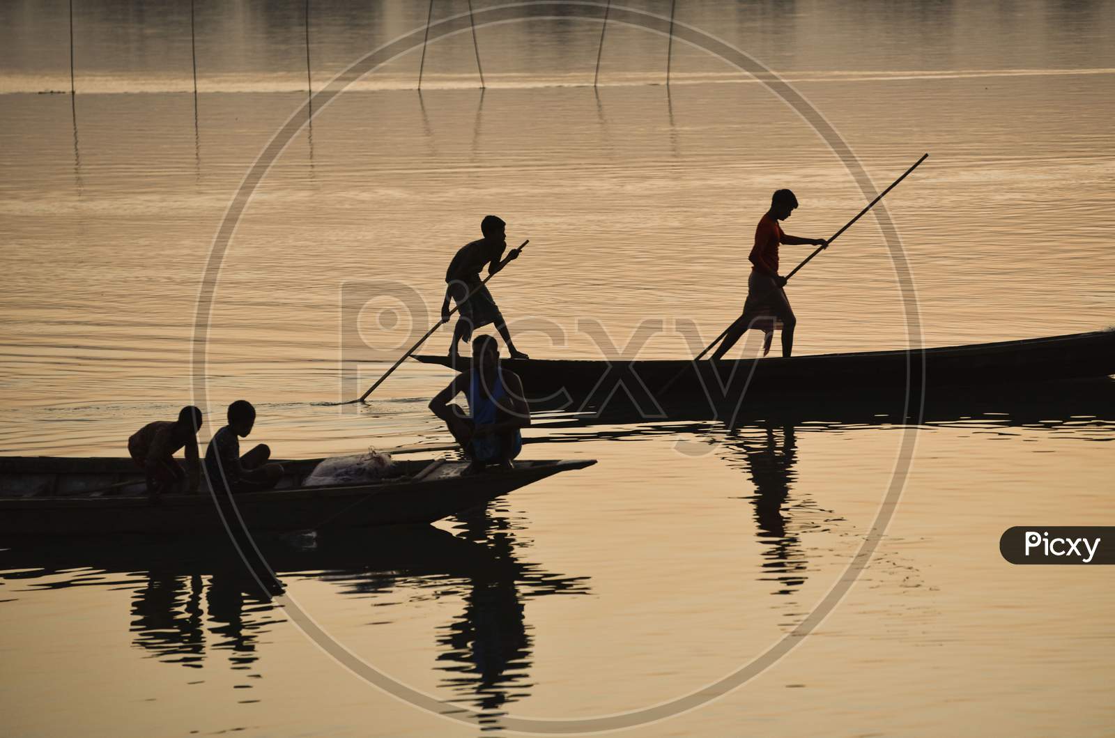 Silhouette Of  Indian Fishermen Fishing In Beki River During Sunset, At Sarbhog In Barpeta District Of Assam