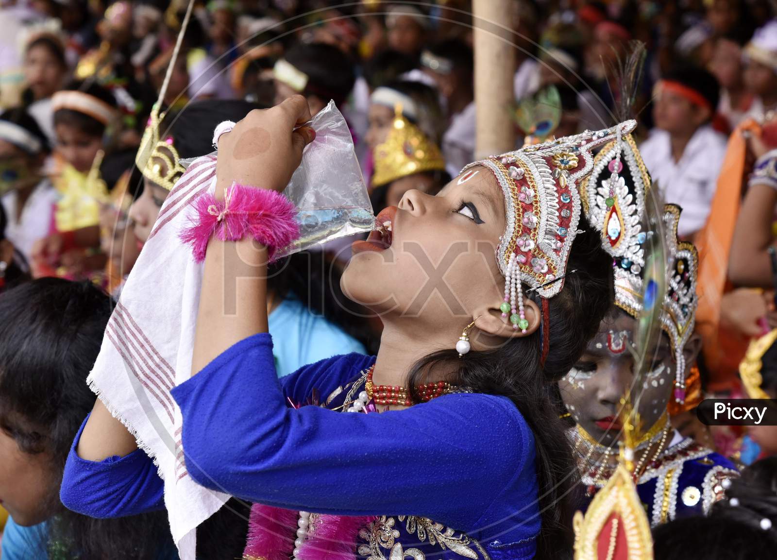 Little Children Dressed Up As Lord Krishna Drinking Water To Beat The Heat During The Janmashtami Festival In Morigaon, Assam, India