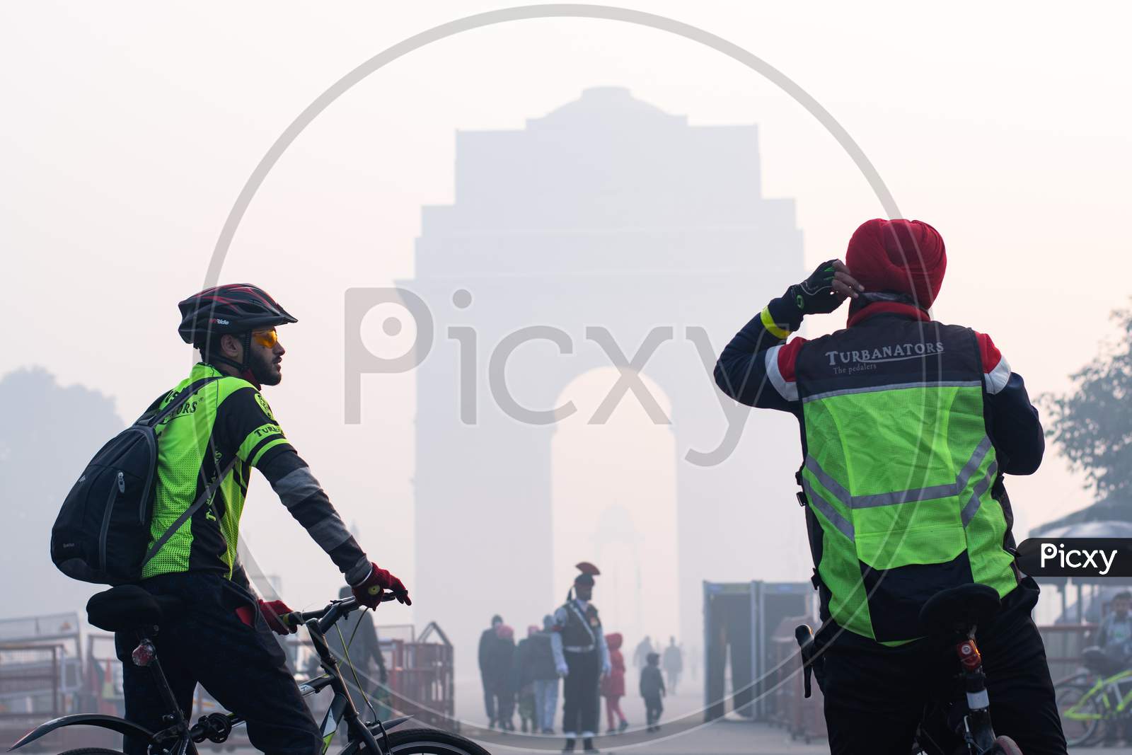 Two cyclists in the foggy morning during winters in front of India Gate in Delhi