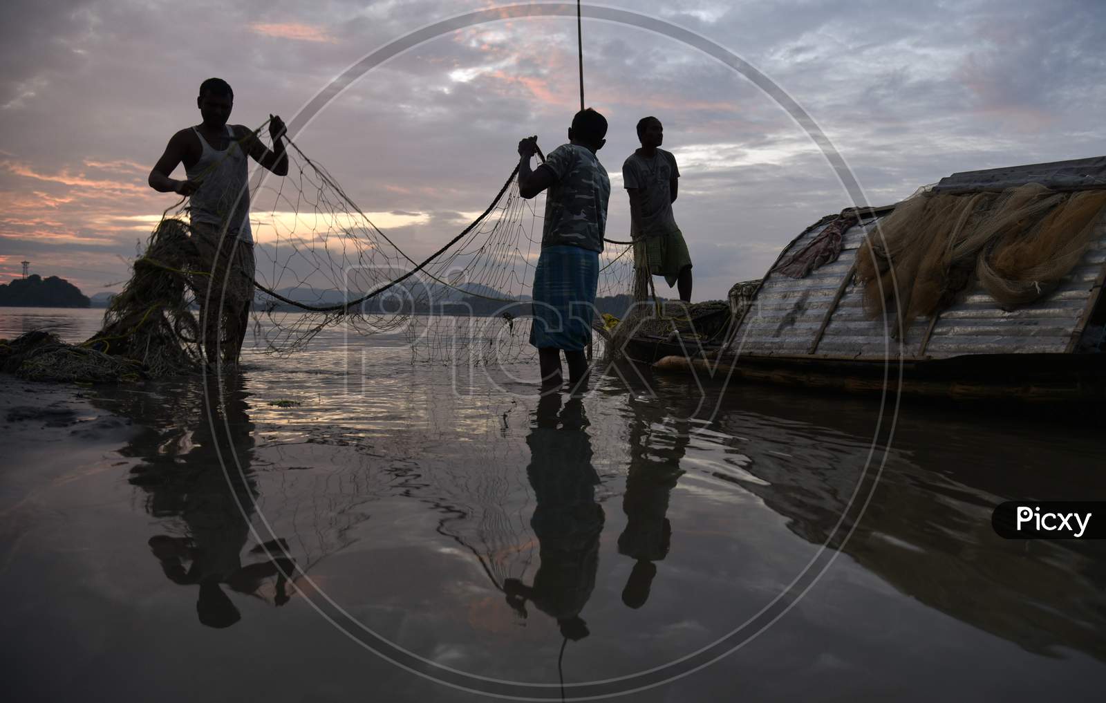 Fisherman cleaning plastics and other materials from their fishing net  after fish in the Brahmaputra, Stock Photo, Picture And Rights Managed  Image. Pic. WF1-3240647