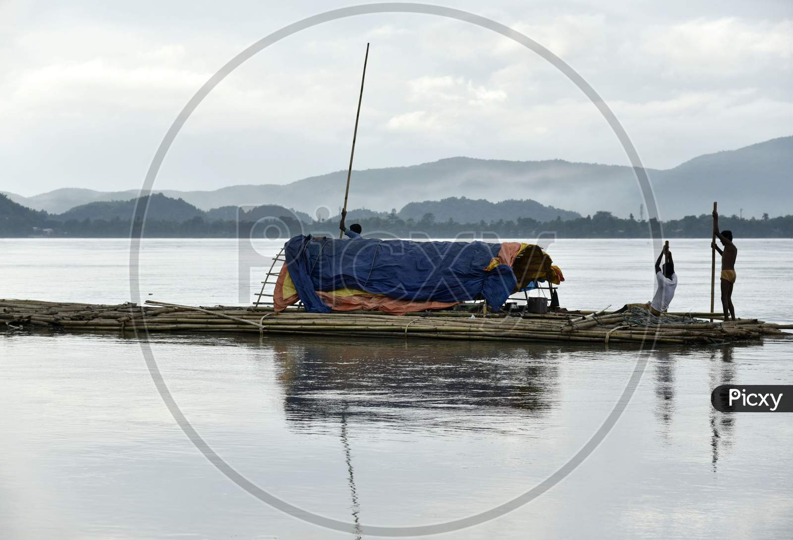 Vendors Steer A Bamboo Pontoon As It Is Transported Down The River Brahamaputra To Sell, In Guwahati, Assam, India On September 14, 2019.