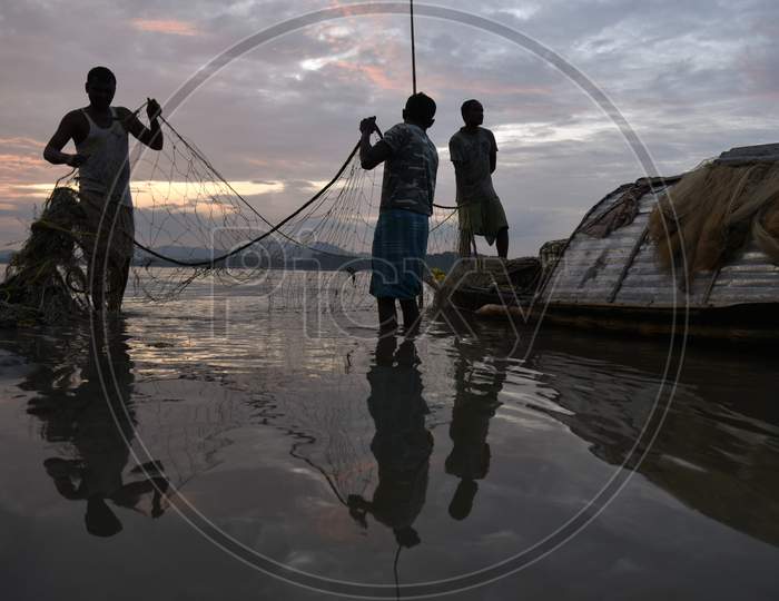 Fisherman In The Brahmaputra River. Guwahati, Assam, India. 09 October 2019. Fishermen Cleaning Their Fishing Nets After Fish In The Brahmaputra River, In Guwahati, Assam On Wednesday, 09 October 2019. Photo: David Talukdar