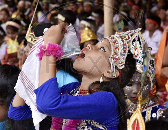 Little Children Dressed Up As Lord Krishna Drinking Water To Beat The Heat During The Janmashtami Festival In Morigaon, Assam, India
