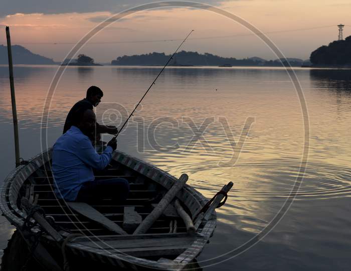 Indian Men Fishing In The Brahmaputra River At Sunset, In Guwahati, Assam