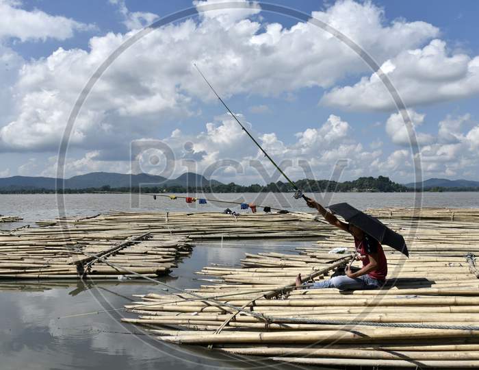 Man Waiting After Lying Their Fishing Rod In The Brahmaputra River, On A Sunny Day In Guwahati, Assam