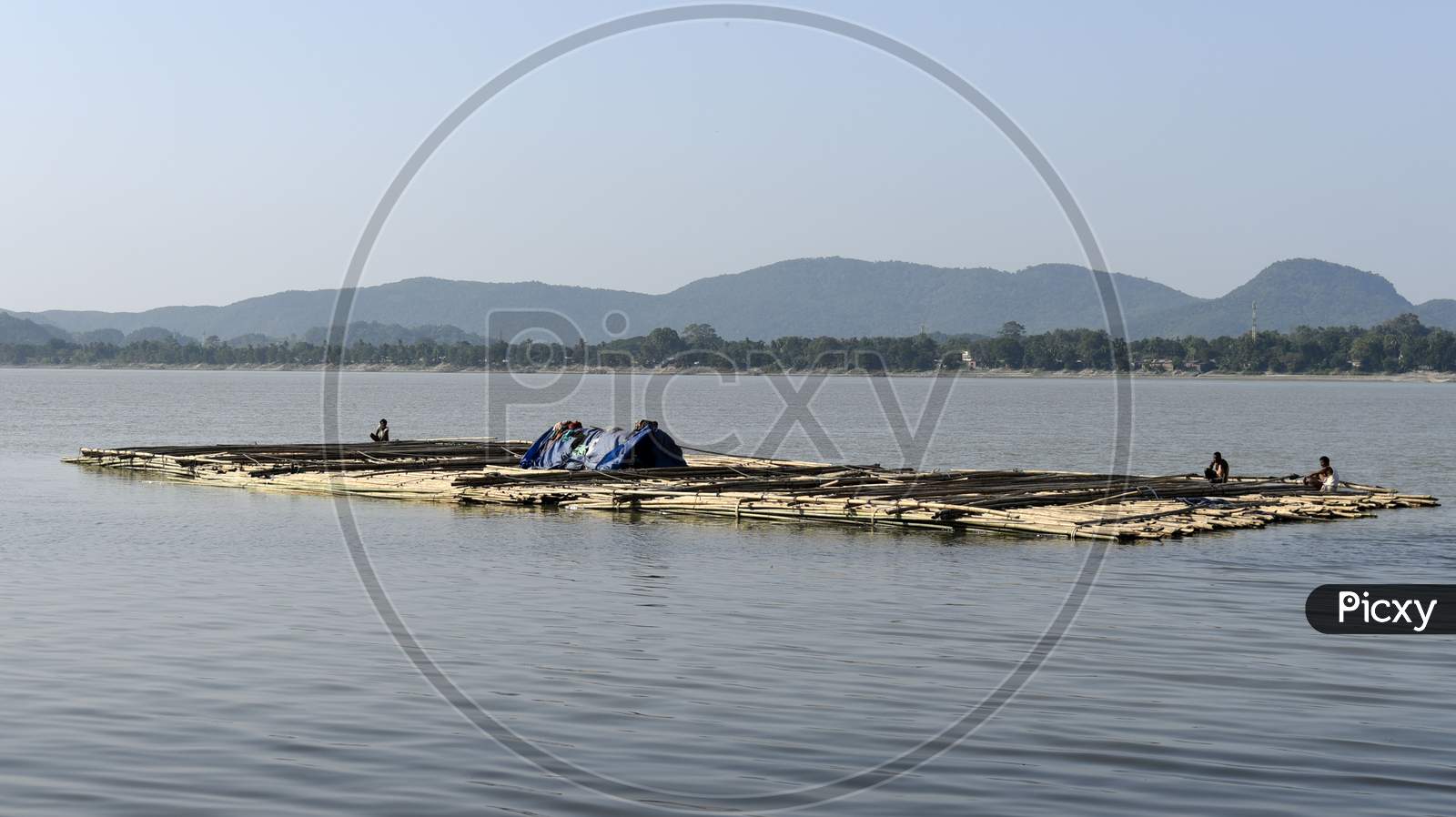Vendors Steer A Bamboo Pontoon As It Is Transported Down The River Brahamaputra To Sell, , In Guwahati