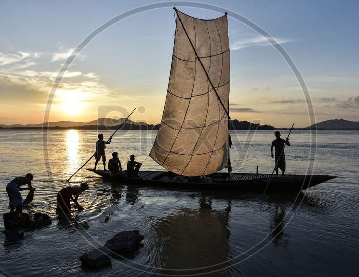 Fishermen Paddle Down The Brahmaputra River After Fish In Guwahati, Assam, India