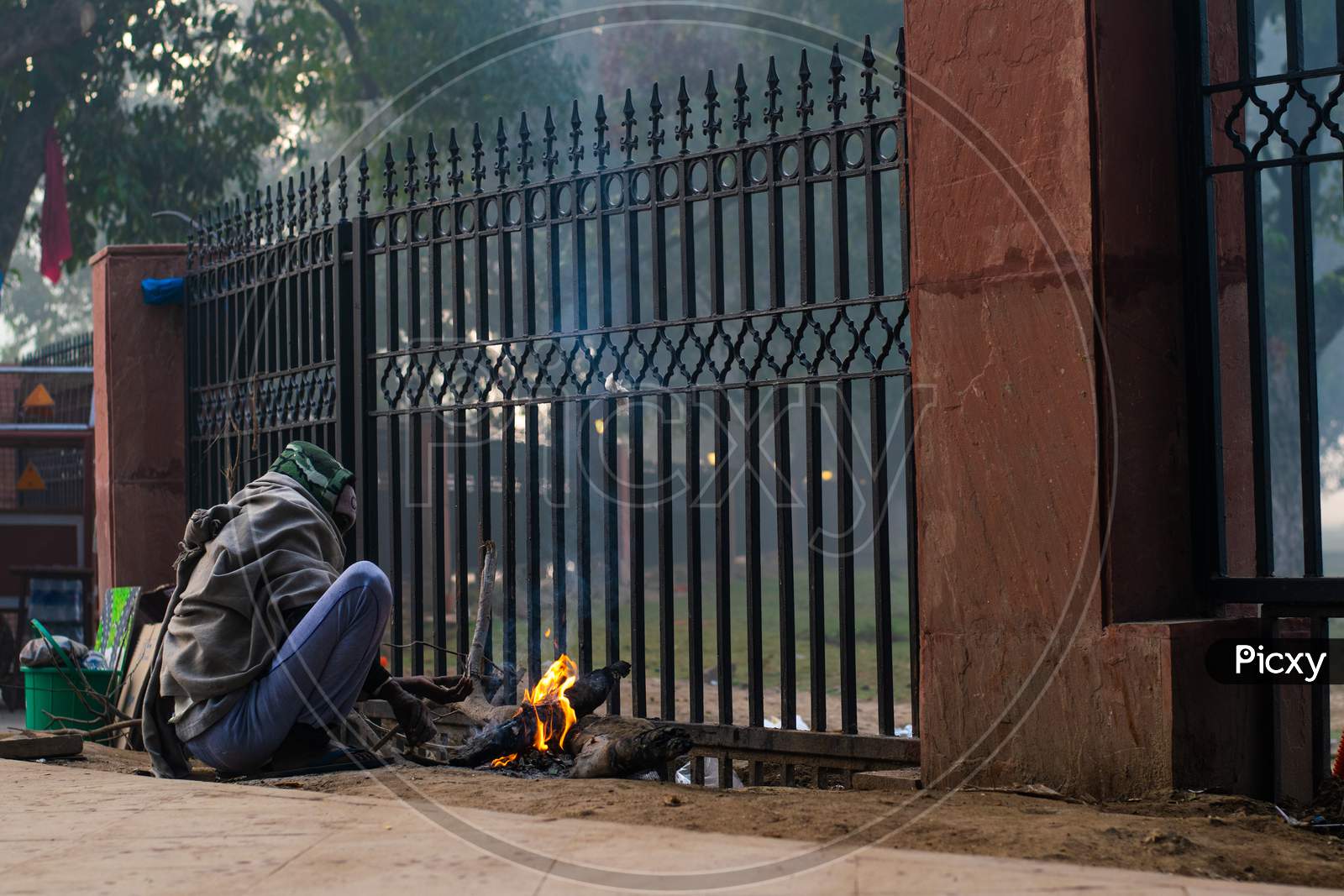 A man lighting bonfire in the foggy morning during winters in Delhi