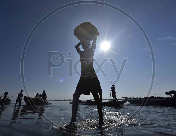 Silhouette of Indian Labourer Carry Extracted Sand From Beki River, In Barpeta District Of Assam