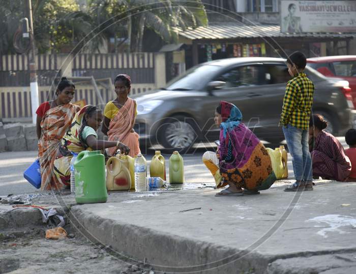 Women Catches Water From A Leakage Pipe