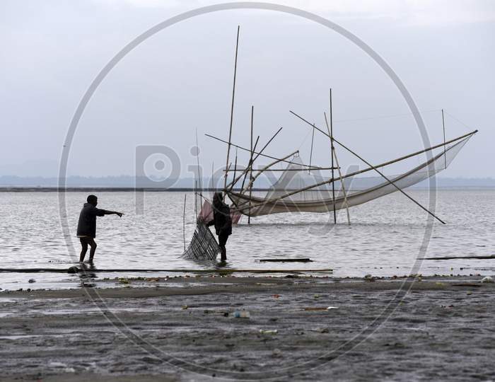 Fisherman Lay Their Bamboo Made Fishing Net In The Brahmaputra River In A Cold Winter Evening, In Guwahati