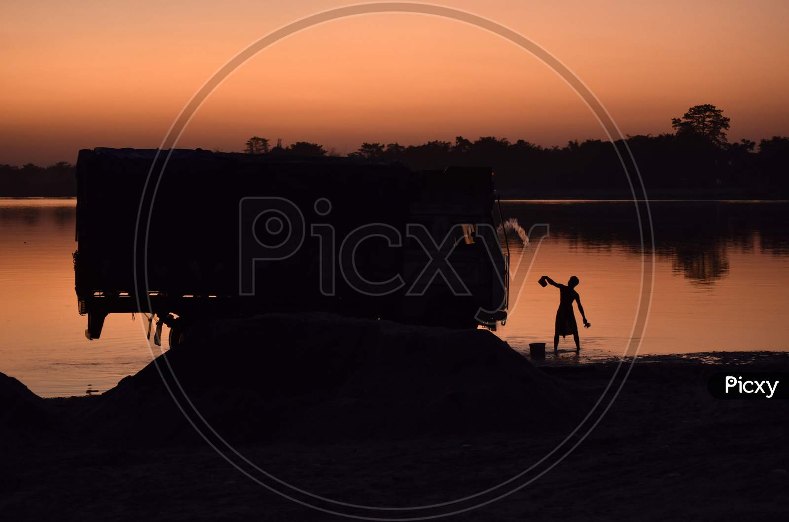 Boy Washing A Truck In Beki River At Sunset, At Sarbhog In Barpeta District Of Assam