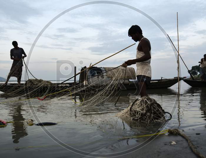 Fisherman In The Brahmaputra River. Guwahati, Assam, India. 09 October 2019. Fishermen Cleaning Their Fishing Nets After Fish In The Brahmaputra River, In Guwahati, Assam On Wednesday, 09 October 2019. Photo: David Talukdar