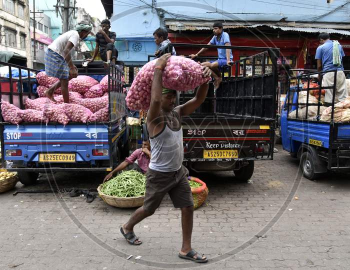 Worker or daily Labor Carrying Onion Bags Over Head In a Market