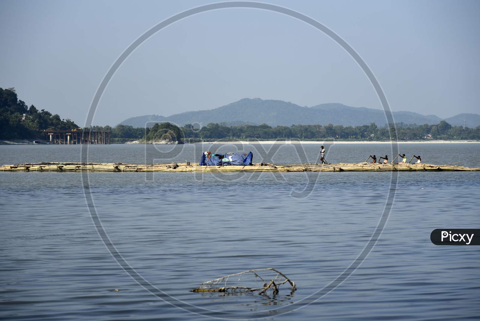 Vendors Steer A Bamboo Pontoon As It Is Transported Down The River Brahamaputra To Sell, , In Guwahati