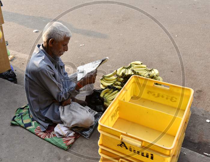 An Old Man Selling Bananas On Road Side