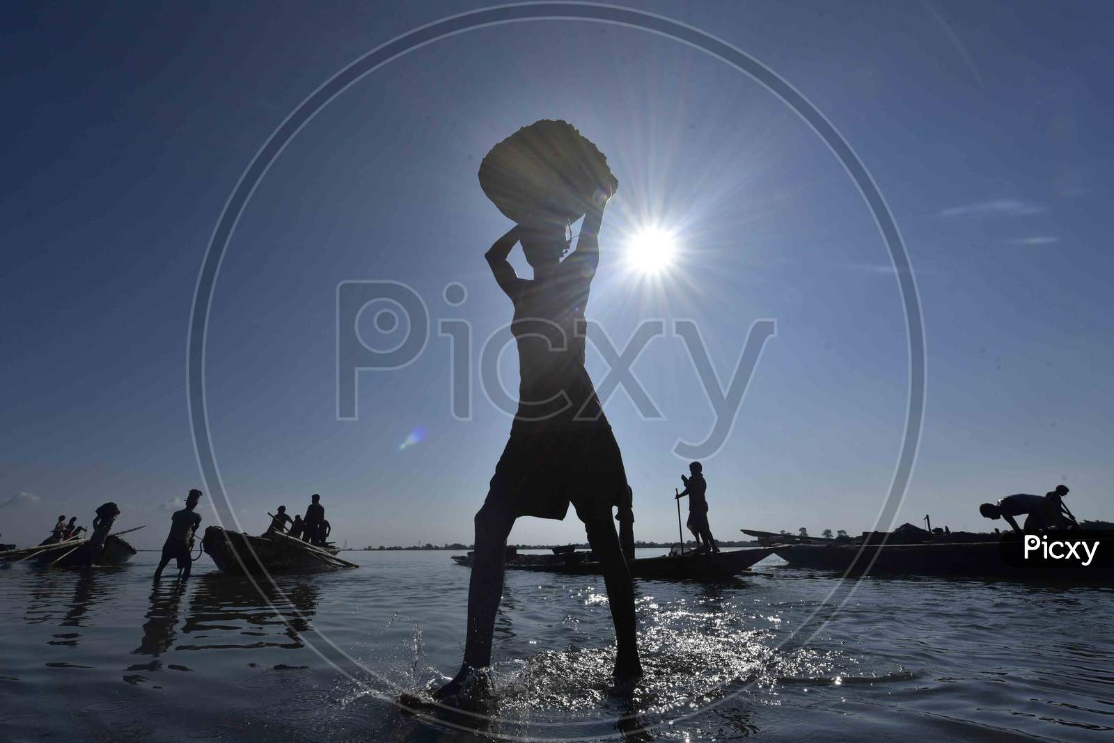 Silhouette of Indian Labourer Carry Extracted Sand From Beki River, In Barpeta District Of Assam
