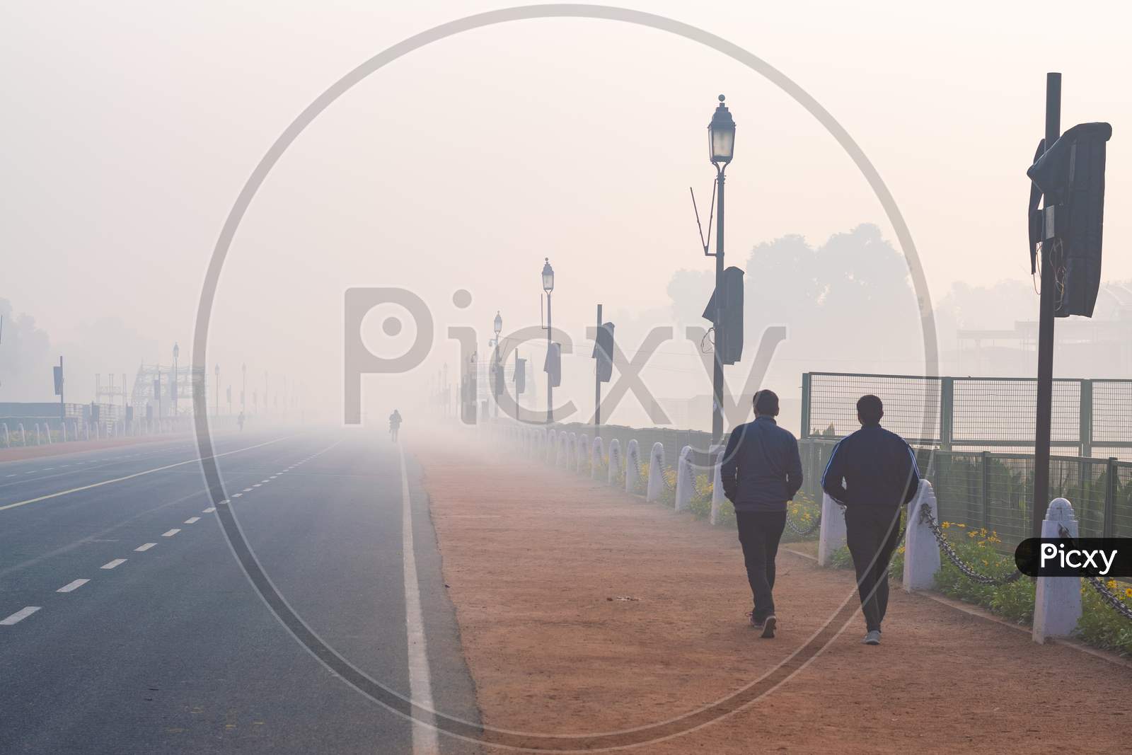 Two men walking in the foggy morning during winters in Delhi