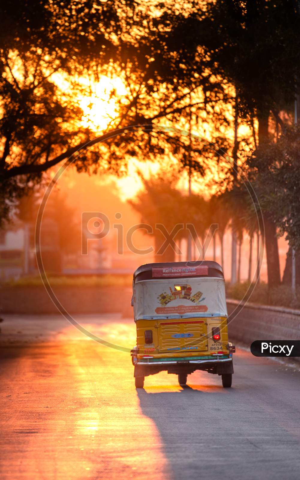 An Auto moving on road during sunrise