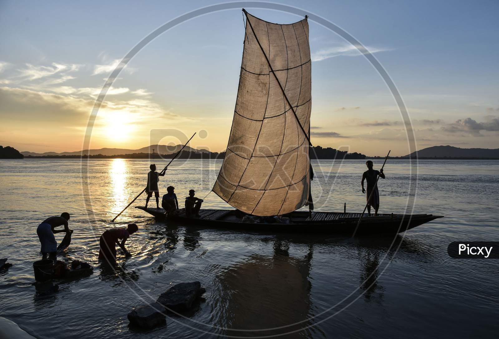 Fishermen Paddle Down The Brahmaputra River After Fish In Guwahati, Assam, India