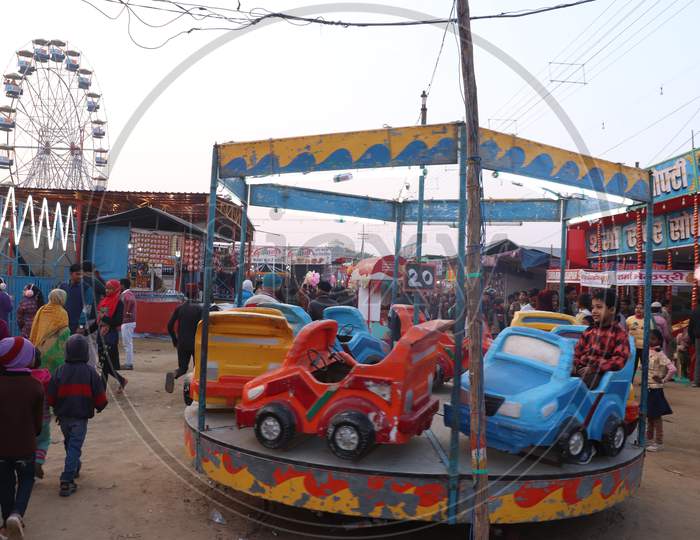 Amusement Rides in an Fair With Children Enjoying Rides