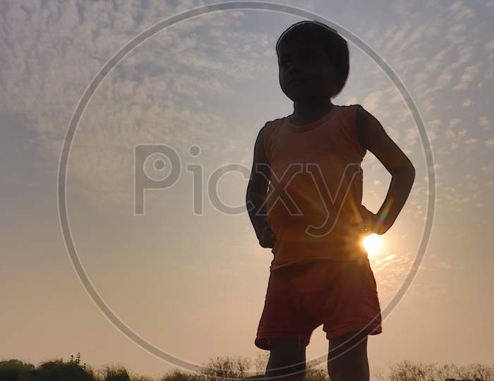 Silhouette Of A Boy over sunset in Indian Rural Villages