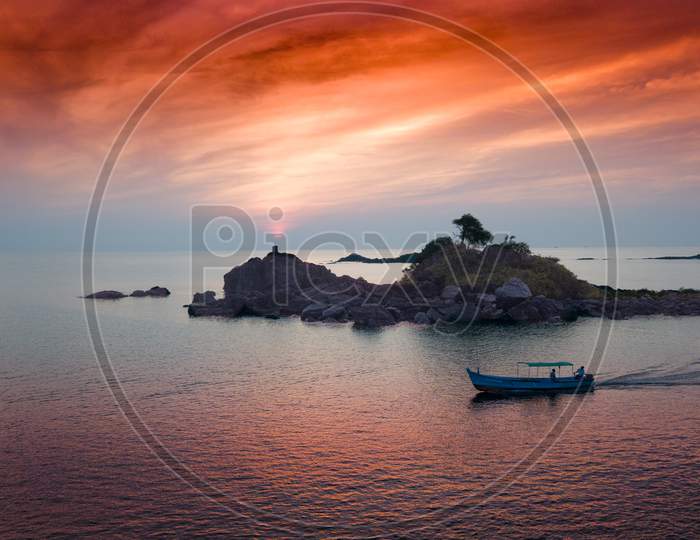 Aerial View Of A Boat On Sea With Sunset Sky In Background