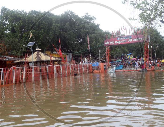 Hindu Devotees Offering Prayers To Lord Bade Hanuman Infront Of Submerged Temple In The Flood Water Of River Ganga In Prayagraj