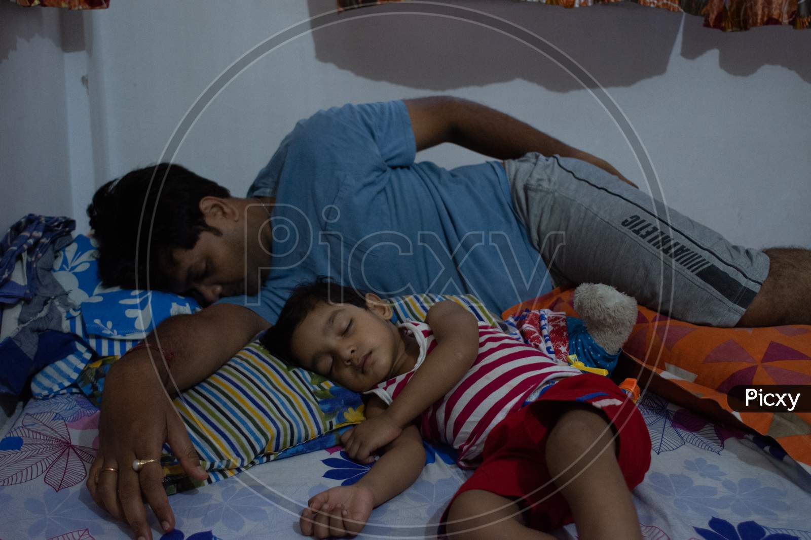 father and son sleeping together in same style. Indian family