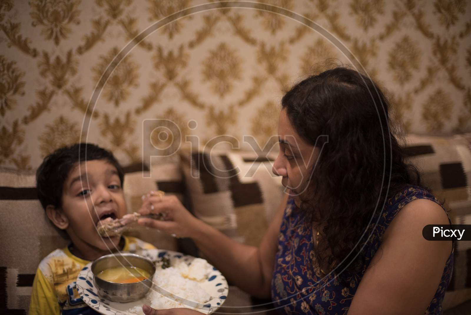Bengali Indian mom trying to feed her baby boy playing with him