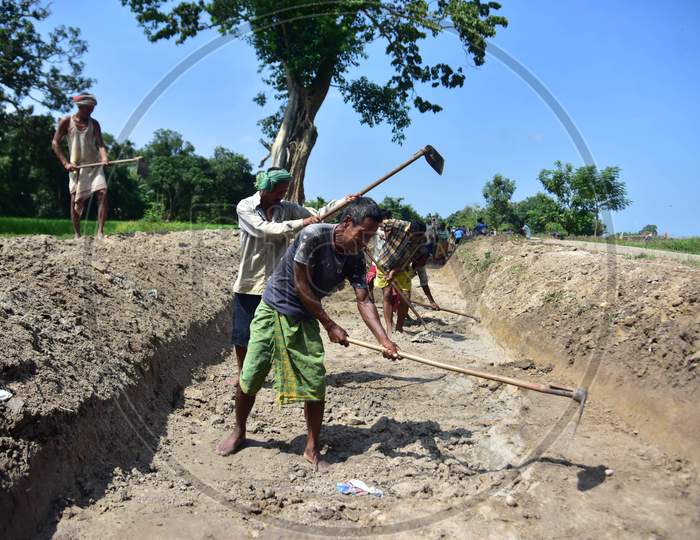 Labourers dig a canal along agricultural fields at a village in Nagaon district of Assam, Thursday, Oct. 1, 2020.