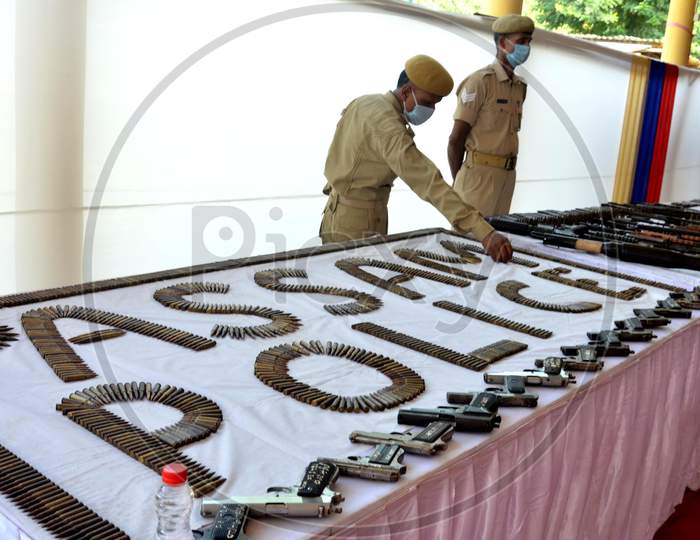 A police personnel arrange arms and ammunition during an exhibition