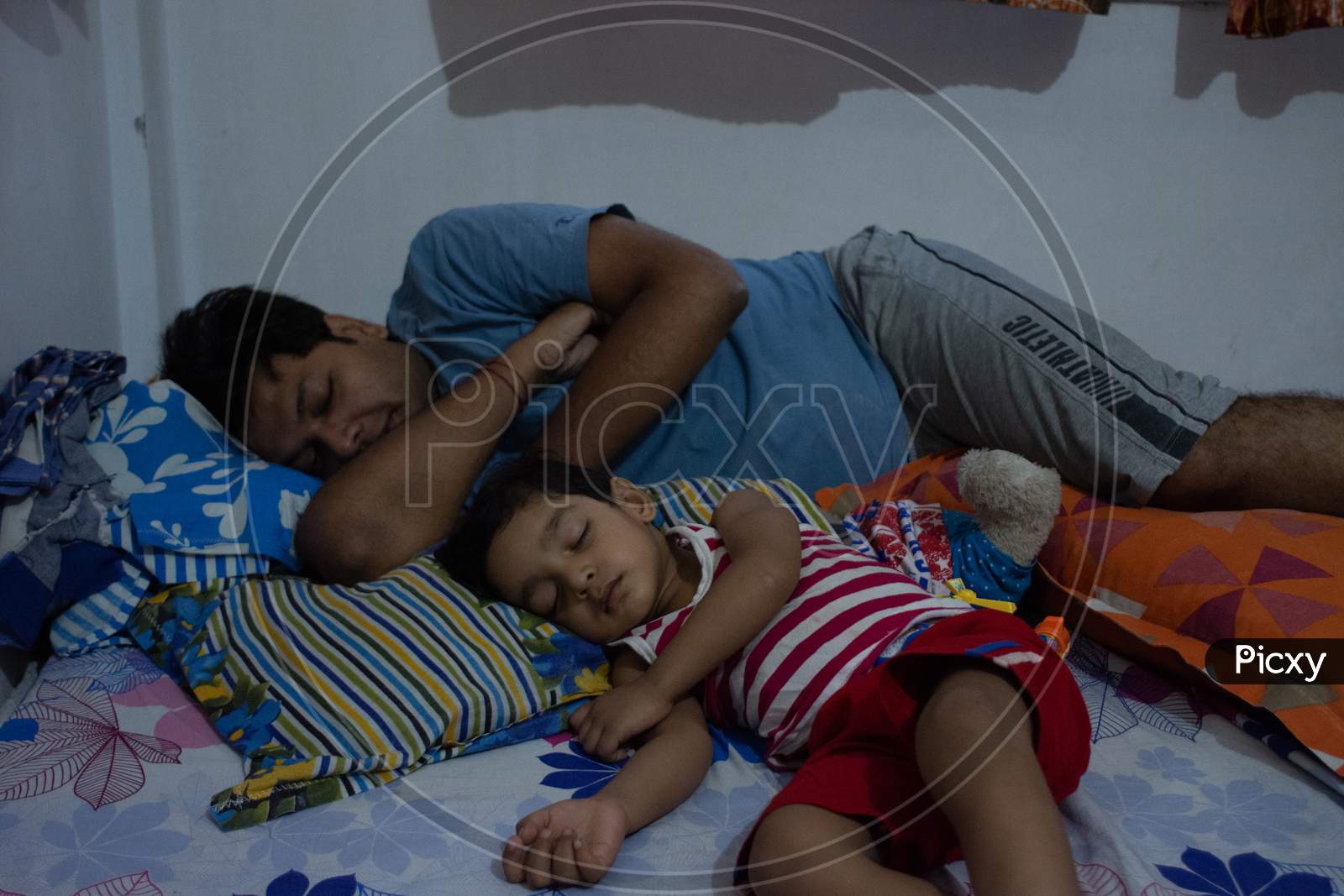 father and son sleeping together in same style. Indian family