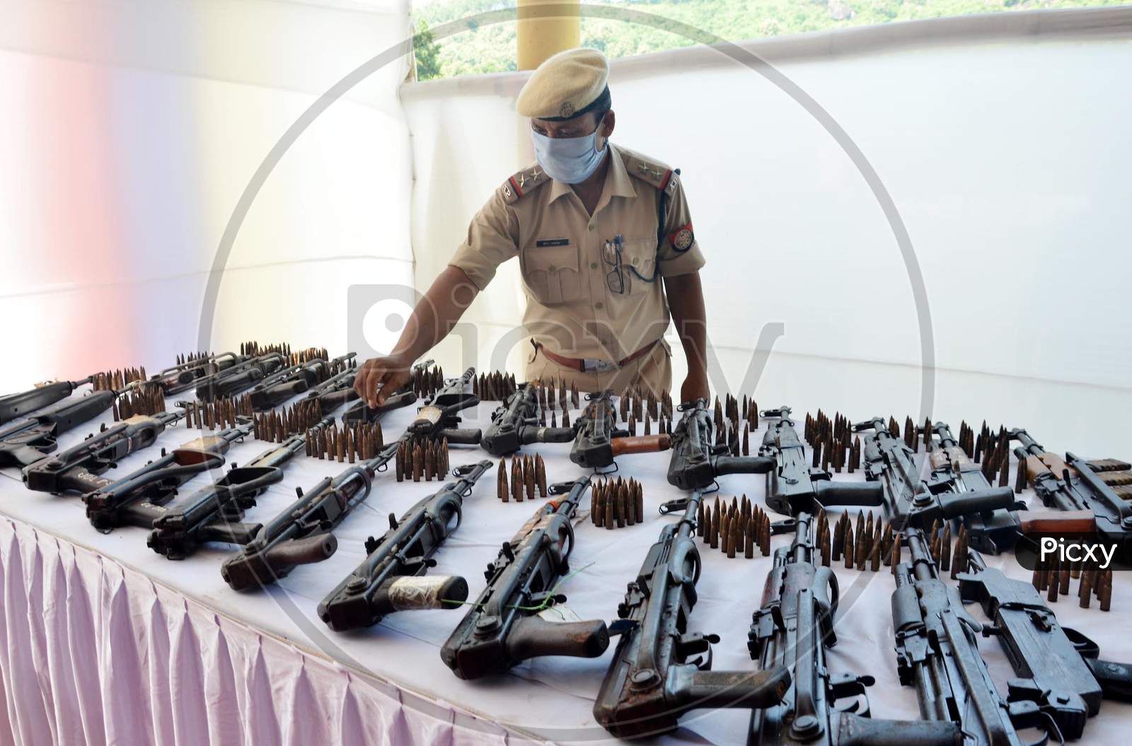 A police personnel arrange arms and ammunition during an exhibition