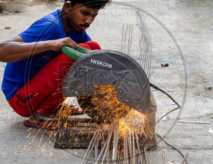 A man using metal cutter to make road into pieces