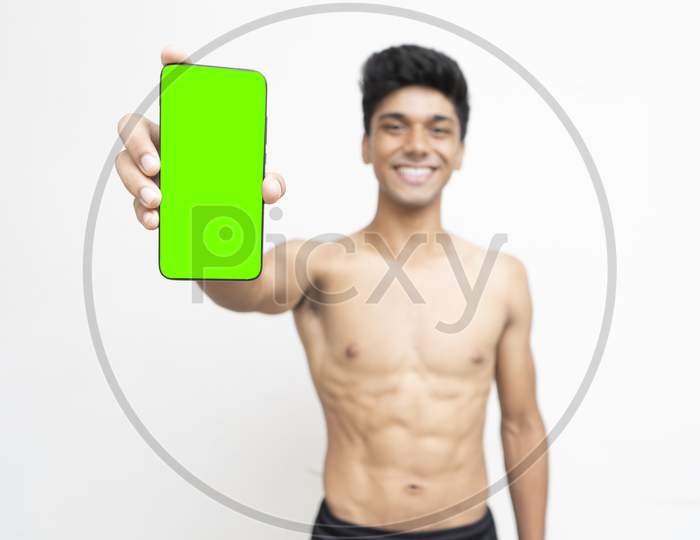 Young Indian Boy Holding A Phone With Green Screen.