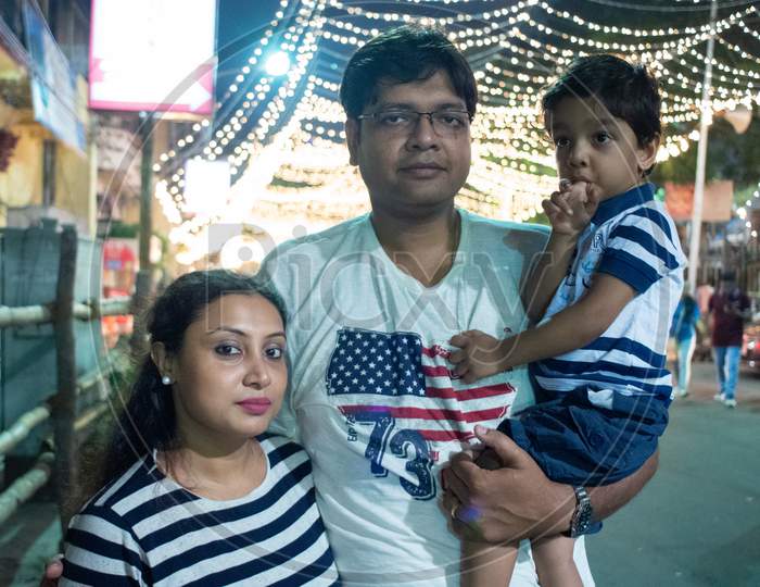 Indian family enjoying festival nighttime. Child and parents