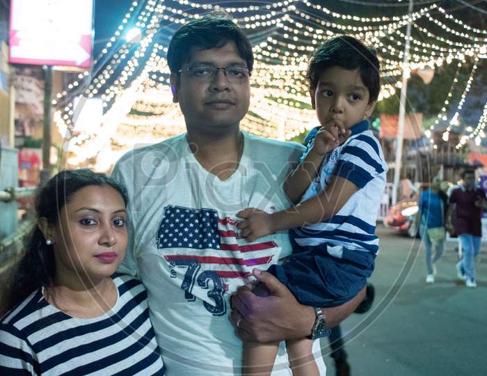 Indian family enjoying festival nighttime. Child and parents