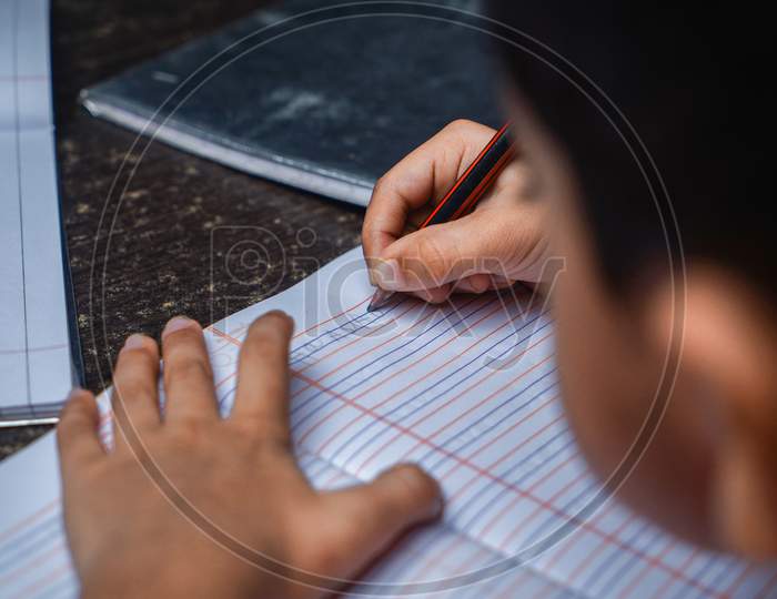 Indian little boy writing in paper